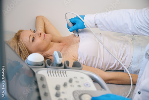 Female getting her breast examined by doctor at modern clinic