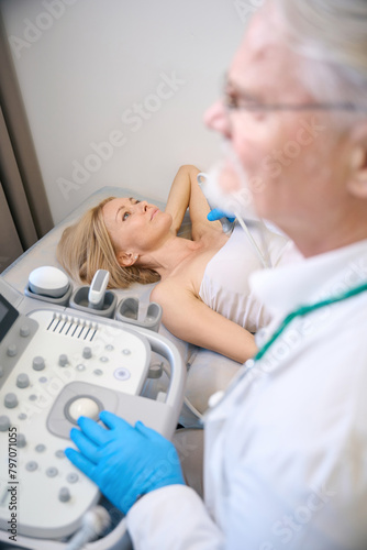 Woman getting her breast examined by doctor at modern clinic