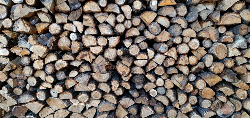 a lot of firewood stacked against the wall, wooden texture background a lot of firewood stacked against the wall, wooden texture background