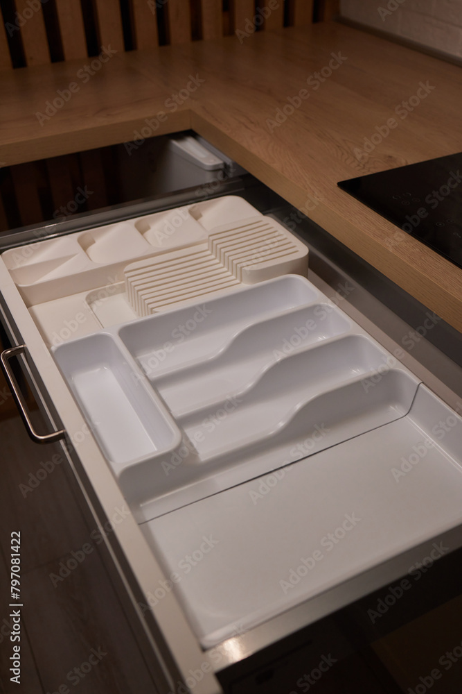 Person grabbing gold fork from black drawer with handles Person grabbing gold fork from black drawer with handles