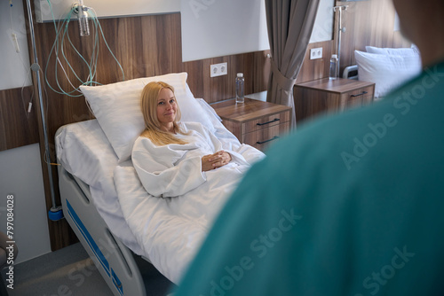 Male physician visiting reassure patient on bed photo