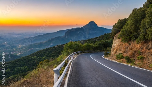 road in mountains kalabaka region meteora greece empty asphalt road with glowing perfect sky and sunlight landscape with beautiful winding mountain road with a perfect asphalt in the evening photo