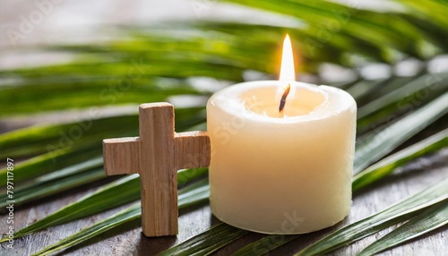 wooden cross candle and palm leaves