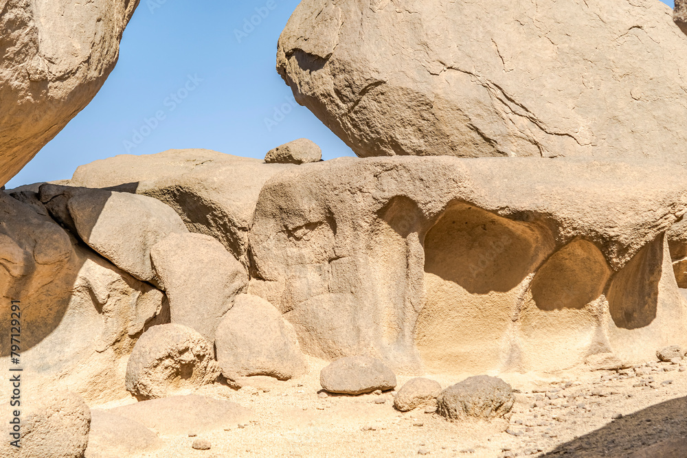 Huge sedimentary rocks naturally sculpted with water and winds in the Sahara desert dry climate with sunlight and shadows and blue sky on background. Huge sedimentary rocks naturally sculpted with water and winds in the Sahara desert dry climate with sunlight and shadows and blue sky on background.