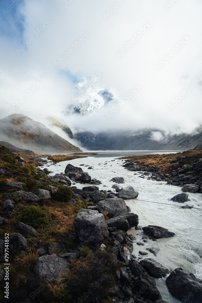Alpine mountain landscape white peak with fog and river
