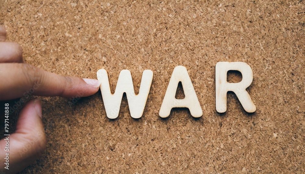 war wood word on compressed or corkboard with human s finger at r letter