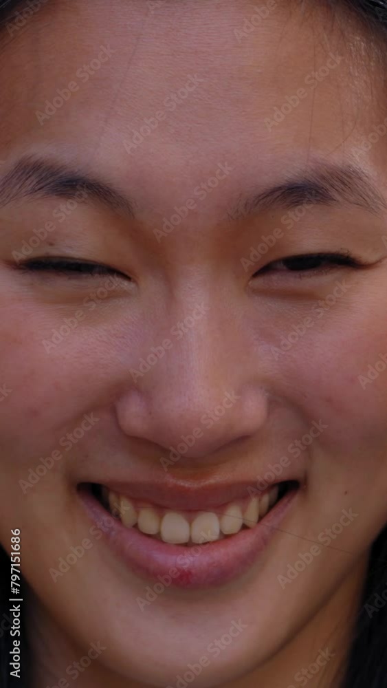 Vertical Close up face of happy beautiful young Asian woman happy smiling on street. Female people with cheerful expression looking at camera in open air. Chinese girl posing for photo outdoor. Vertical Close up face of happy beautiful young Asian woman happy smiling on street. Female people with cheerful expression looking at camera in open air. Chinese girl posing for photo outdoor.