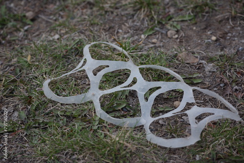 Six-pack can holder, trash, on grassy ground, macro