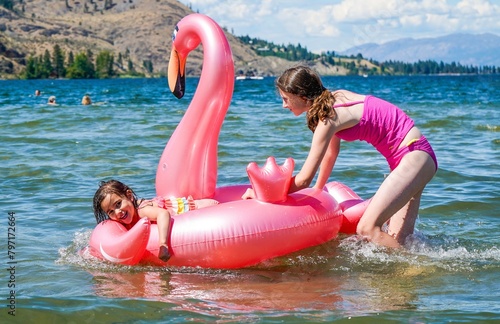 Girls playing at lake with an inflatible toy  photo