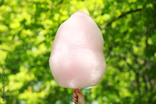 Woman holding sweet cotton candy outdoors, closeup © New Africa