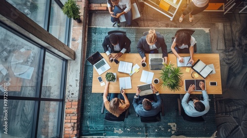 Top view angle of meeting atmosphere of office workers at meeting table with stationry report file.