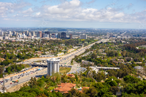 View over the busy 405 highway and Century City on a partly cloudy day seen from the Santa Monica Mountains in Los Angeles 