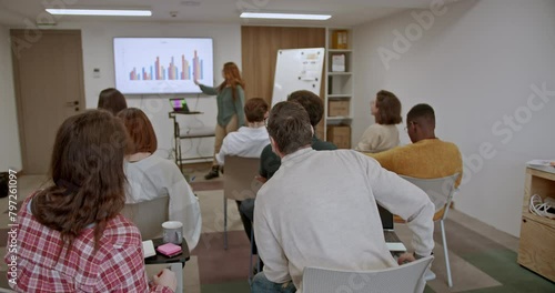 Business coworkers are engaged in a training seminar within a modern corporate classroom, showcasing their commitment to professional development and continuous learning.