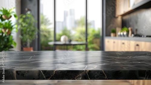 Modern kitchen interior with empty dark marble table top or island, and a blurry bokeh background for product display montage.