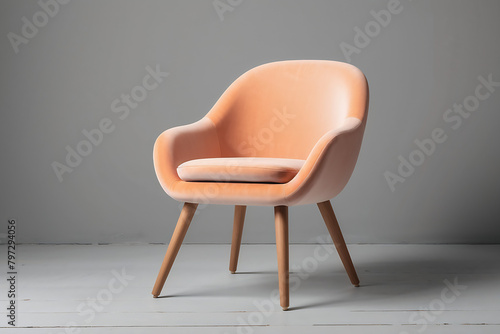 Modern Velour Chair Peach Fuzz, color of the year 2024 on wooden legs, grey background photo
