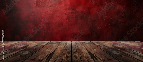 A simple wooden table is placed in front of a wall painted in a striking red color, creating a bold and vibrant contrast