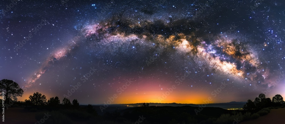Scenic view of the milky way and twinkling stars illuminating the dark sky above majestic mountain summits Scenic view of the milky way and twinkling stars illuminating the dark sky above majestic mountain summits