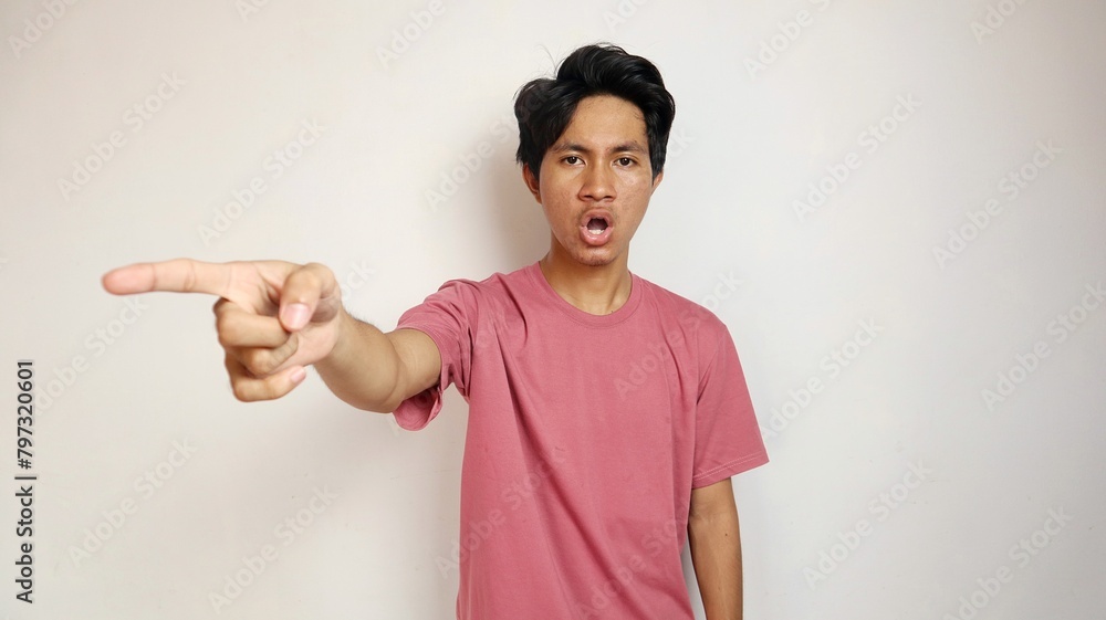Excited young handsome Asian man happy, cheerful and enthusiastic posing pointing to the front side with an isolated white background Excited young handsome Asian man happy, cheerful and enthusiastic posing pointing to the front side with an isolated white background