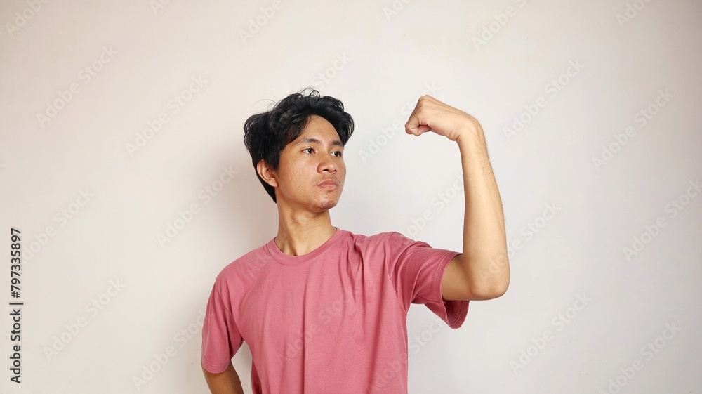 Handsome young Asian man posing showing his brave muscles on an isolated white background Handsome young Asian man posing showing his brave muscles on an isolated white background