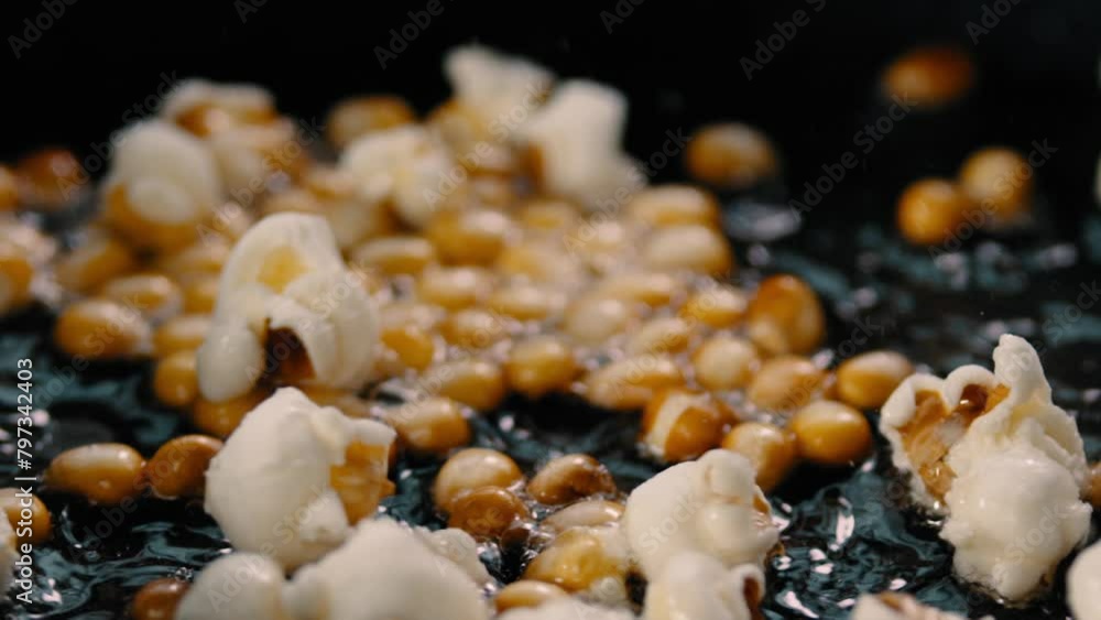 Corn kernels in a hot pan popping into popcorn
