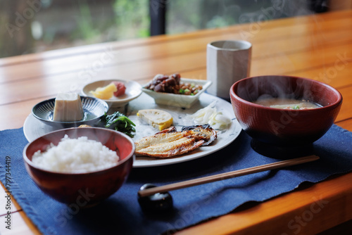Japanese breakfast includes grilled fish, miso soup, tofu, rice, Japanese pickled vegetables, and Japanese green tea.