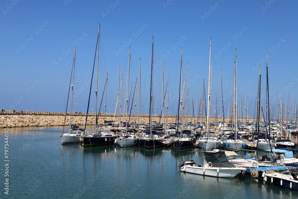 Masts in the port against the blue sky.