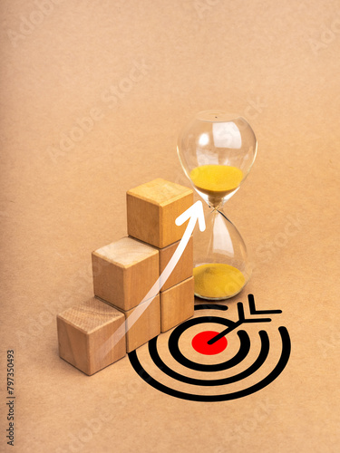 Return on Investment financial (ROI), business success and marketing goal concepts. Rise arrow on wooden cube blocks as growth graph steps near hourglass on eco brown background with big target icon.