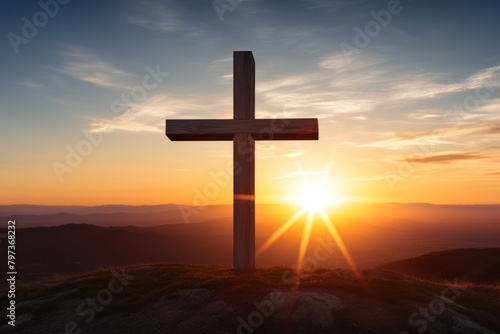 a cross on a hill with the sun in the background