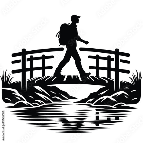 silhouette of a hiker crossing wooden bridge over stream
