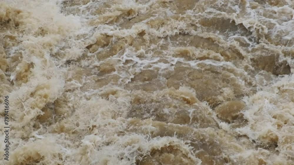 Dirty spring muddy Water in the river with foam. Masses of water fall from the dam, a strong flow of turbid water during half-water. Dirty spring muddy Water in the river with foam. Masses of water fall from the dam, a strong flow of turbid water during half-water.