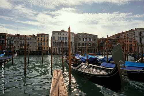 A serene view of gondolas moored along a sun-kissed canal in Venice, Italy.
