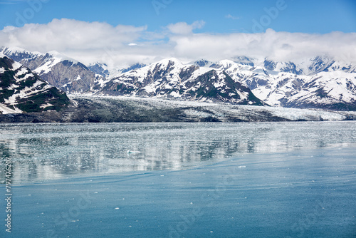 Spiegeling in het water met ijsschotsen met uitzicht op een gletsjer en met sneeuw bedekte bergen in Alaska.