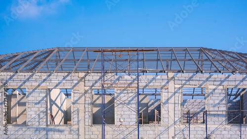 Foto Concrete block wall with metal hip roof beam structure of incomplete modern offi
