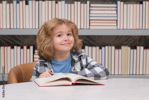 Child reading a book in a school library. School boy education concept.