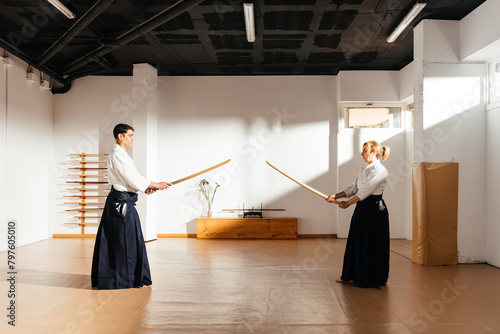Two Martial Artists Engaging in Sword Practice at a Dojo During Daylight