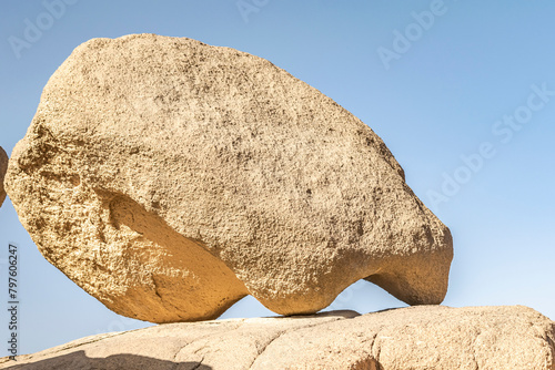 Huge sedimentary rocks naturally sculpted in the Sahara desert dry climate with sunlight and  blue sky on background. Low angle view.