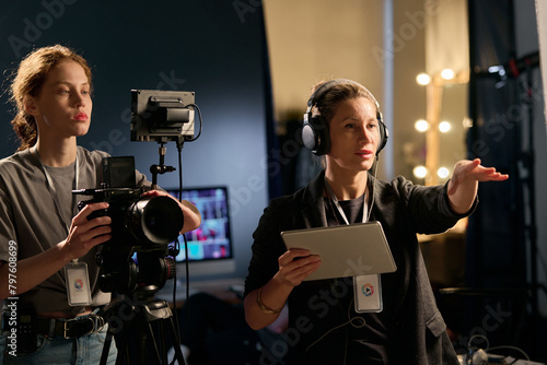 Photography Waist up portrait of female director giving instructions on set during film prod