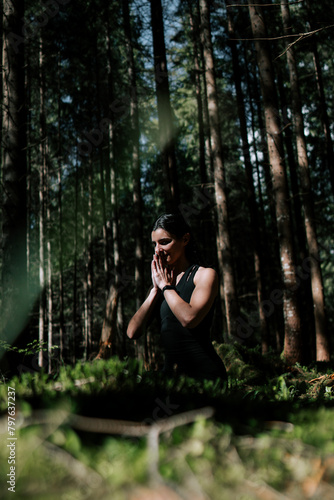 A young woman does yoga and meditates in the forest. Yoga and meditation concept. Yoga asanas. 