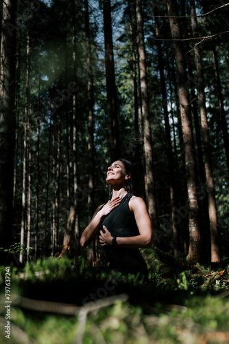 A young woman does yoga and meditates in the forest. Yoga and meditation concept. Yoga asanas. 