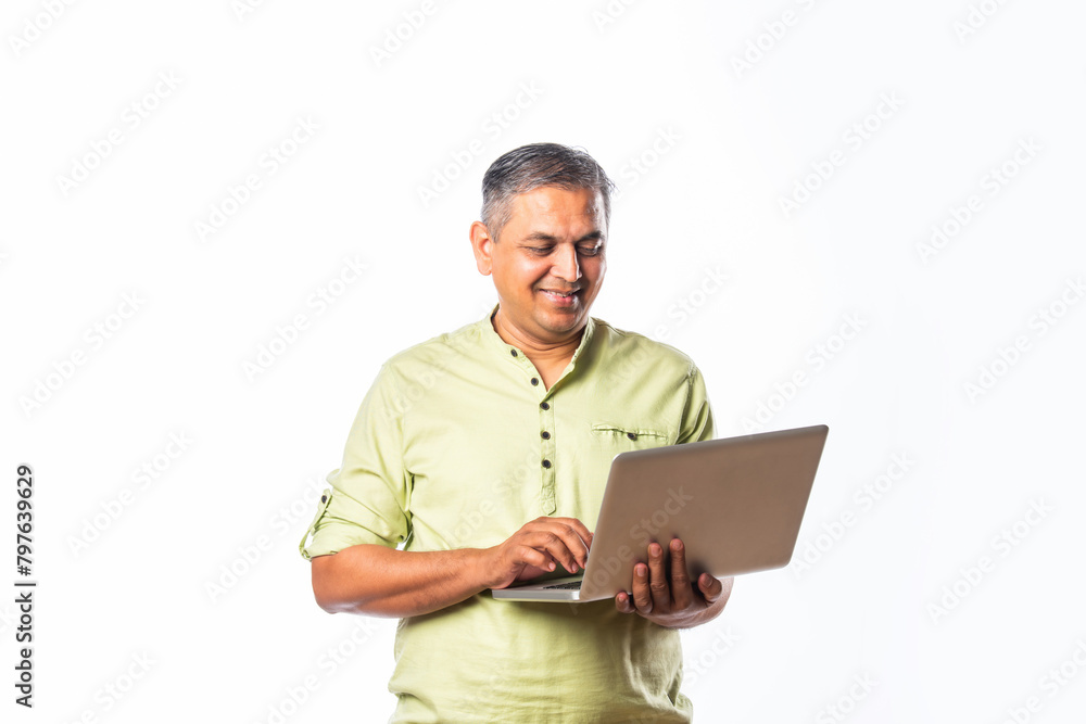 Indian asian mid age man using laptop against white background Indian asian mid age man using laptop against white background