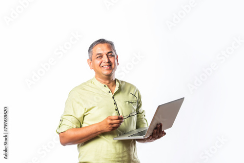 Indian asian mid age man using laptop against white background photo