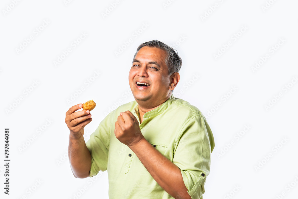 Indian asian handsome man in 40s eats tasty golgappa against white background Indian asian handsome man in 40s eats tasty golgappa against white background