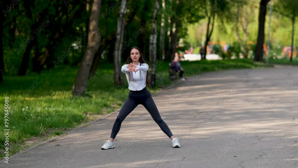 A young cute girl is doing gymnastics in the park. Healthy lifestyle concept. A young cute girl is doing gymnastics in the park. Healthy lifestyle concept.