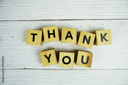 Thank you alphabet letters with wooden block top view on wooden background