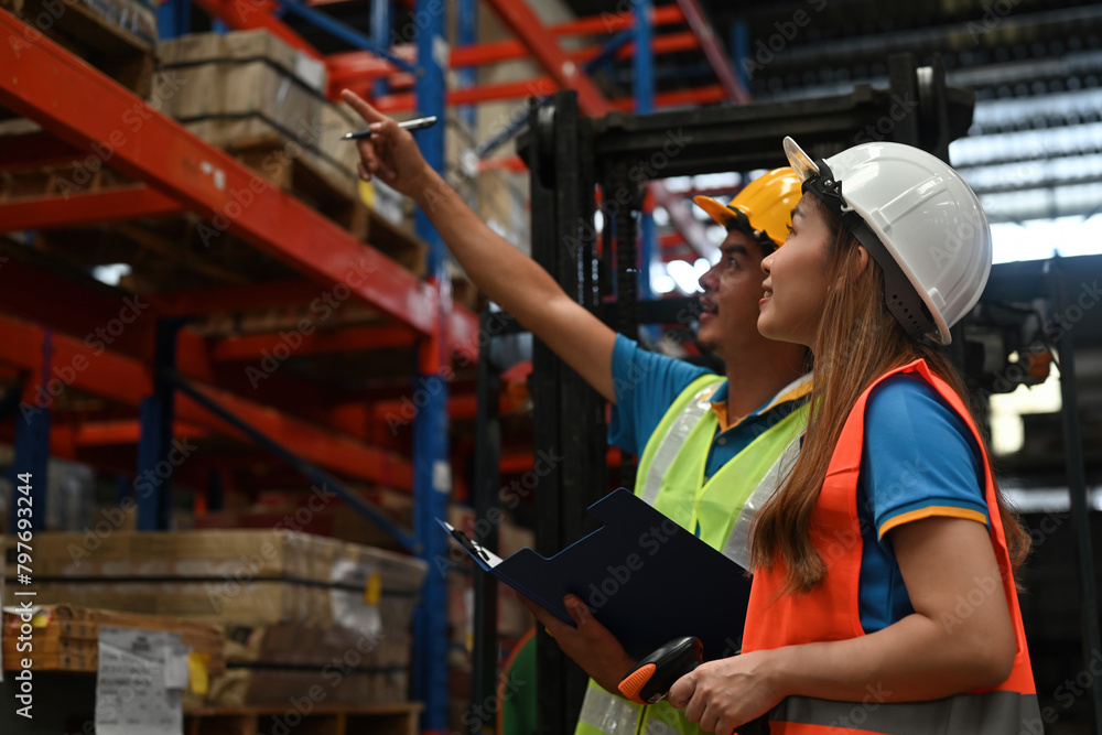 Two warehouse workers do a stocktaking of product management on shelves in the warehouse. Physical inventory count and check to control the stock in the factory. Two warehouse workers do a stocktaking of product management on shelves in the warehouse. Physical inventory count and check to control the stock in the factory.