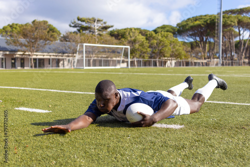 African American young male athlete scoring a try a rugby ball on a field