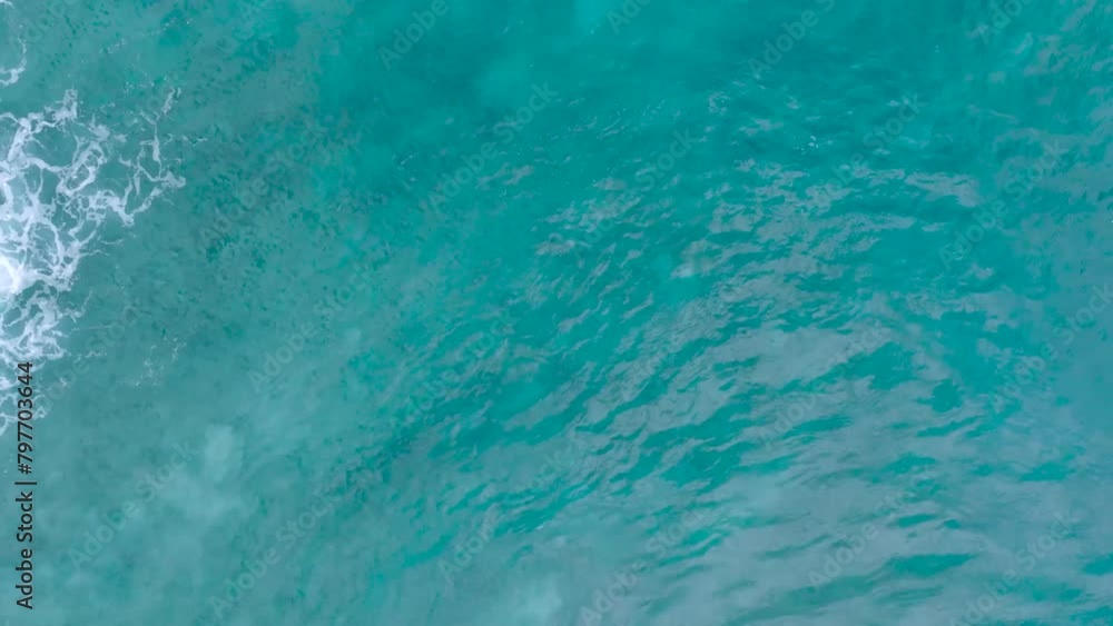 Top Down Slow Motion Drone View of turquoise clear water and crashing waves over shallow coral reef in Uluwatu Bali Indonesia. Clear water and abstract wave action. Top Down Slow Motion Drone View of turquoise clear water and crashing waves over shallow coral reef in Uluwatu Bali Indonesia. Clear water and abstract wave action.