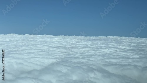 POV overflying a blanket of stratus clouds, shot from an airplane cabin. 4K 60FPS