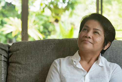 Thoughtful aged asian woman planning, Aunt looking up and thinking about good idea