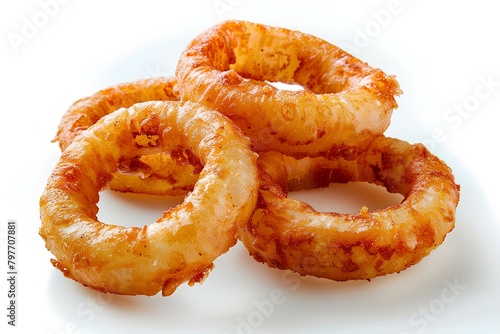 A pile of fried onion rings on a white surface with a white background and a few pieces of fried